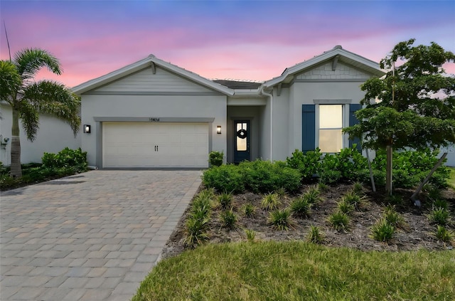 10036 Beachwalk Dr, Englewood, FL 34223 - ranch-style house with stucco siding, a garage, and decorative driveway