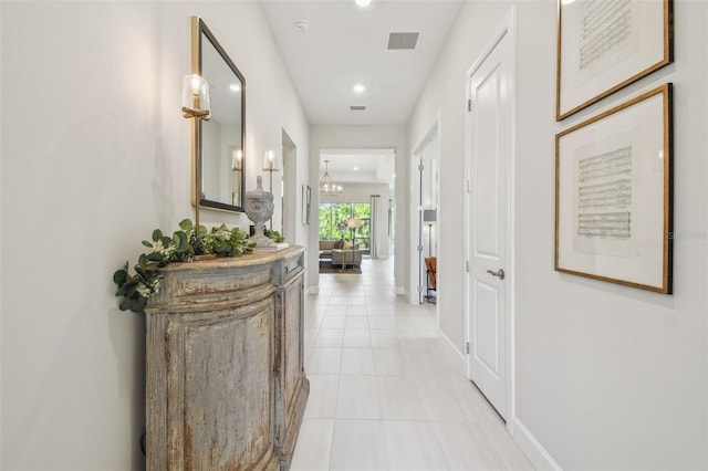 10036 Beachwalk Dr, Englewood, FL 34223 - hallway featuring light tile patterned flooring, recessed lighting, baseboards, and a chandelier
