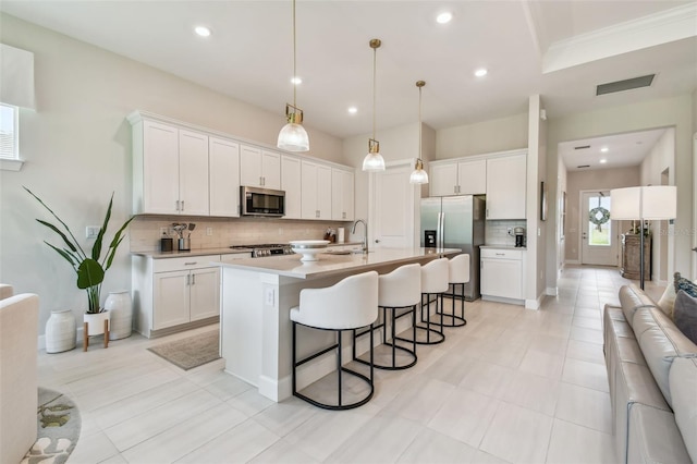 10036 Beachwalk Dr, Englewood, FL 34223 - kitchen featuring stainless steel appliances, tasteful backsplash, a kitchen breakfast bar, white cabinets, and recessed lighting