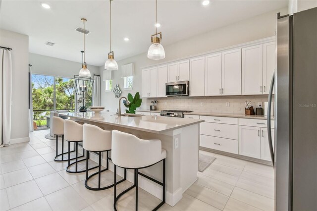 10036 Beachwalk Dr, Englewood, FL 34223 - kitchen featuring stainless steel appliances, a sink, tasteful backsplash, white cabinetry, and recessed lighting