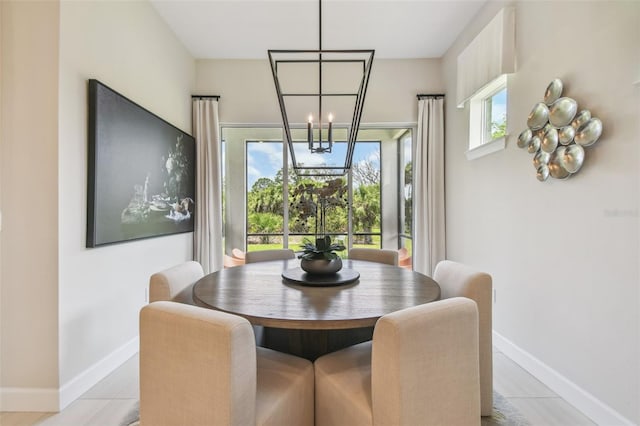 10036 Beachwalk Dr, Englewood, FL 34223 - dining area with baseboards, a chandelier, and light tile patterned floors