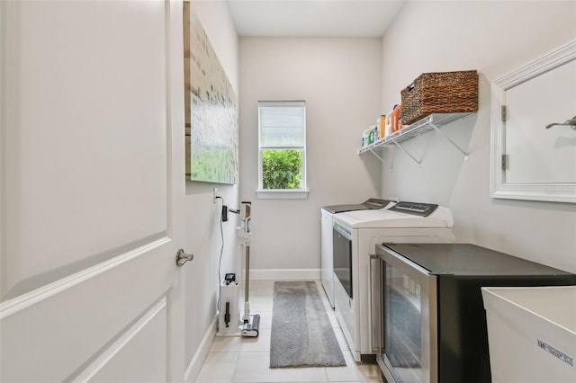 10036 Beachwalk Dr, Englewood, FL 34223 - washroom with washing machine and dryer, light tile patterned flooring, and baseboards