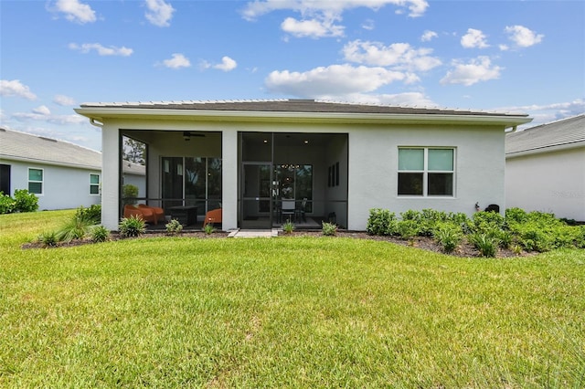 10036 Beachwalk Dr, Englewood, FL 34223 - rear view of house with a sunroom, a lawn, and stucco siding