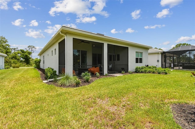 10036 Beachwalk Dr, Englewood, FL 34223 - rear view of house featuring a yard, stucco siding, ceiling fan, and a lanai