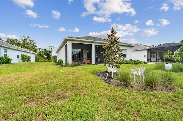 10036 Beachwalk Dr, Englewood, FL 34223 - back of house featuring a sunroom, a yard, and stucco siding