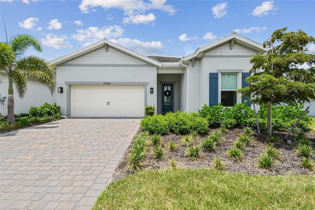 10036 Beachwalk Dr, Englewood, FL 34223 - ranch-style house featuring decorative driveway, stucco siding, and a garage