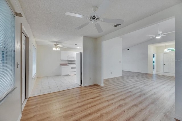 746 Masterpiece Dr, Sun City Center, FL 33573 - unfurnished living room featuring light wood finished floors, a ceiling fan, plenty of natural light, and a textured ceiling