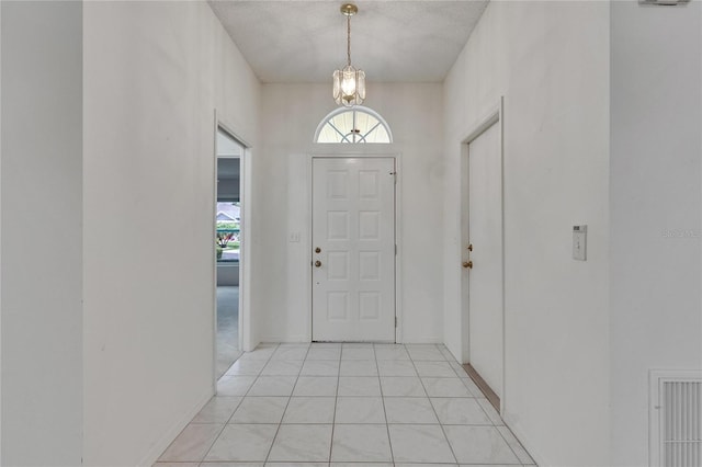 746 Masterpiece Dr, Sun City Center, FL 33573 - foyer entrance with a chandelier and light tile patterned floors