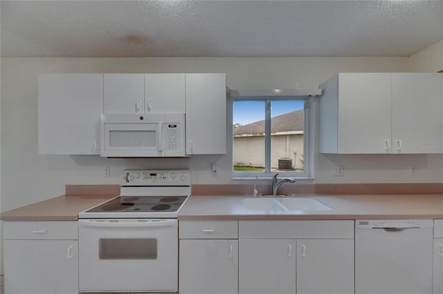 746 Masterpiece Dr, Sun City Center, FL 33573 - kitchen with white appliances, a sink, light countertops, white cabinetry, and a textured ceiling