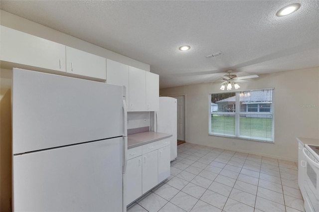 746 Masterpiece Dr, Sun City Center, FL 33573 - kitchen featuring white appliances, a textured ceiling, ceiling fan, light countertops, and white cabinets