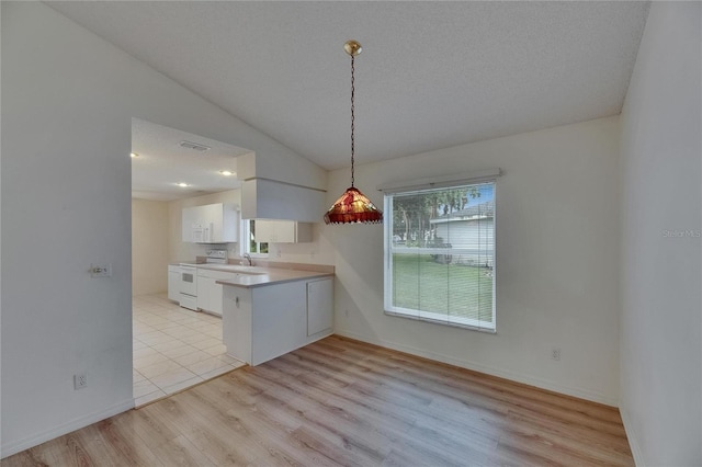 746 Masterpiece Dr, Sun City Center, FL 33573 - kitchen featuring white range with electric cooktop, white cabinetry, a peninsula, light wood finished floors, and lofted ceiling