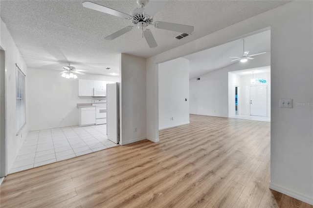 746 Masterpiece Dr, Sun City Center, FL 33573 - unfurnished living room with ceiling fan, light wood-style floors, and a textured ceiling