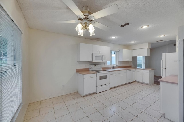 746 Masterpiece Dr, Sun City Center, FL 33573 - kitchen with white appliances, a ceiling fan, light countertops, a textured ceiling, and white cabinetry
