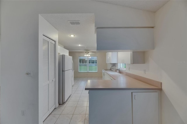 746 Masterpiece Dr, Sun City Center, FL 33573 - kitchen featuring freestanding refrigerator, white cabinets, light tile patterned floors, and a peninsula