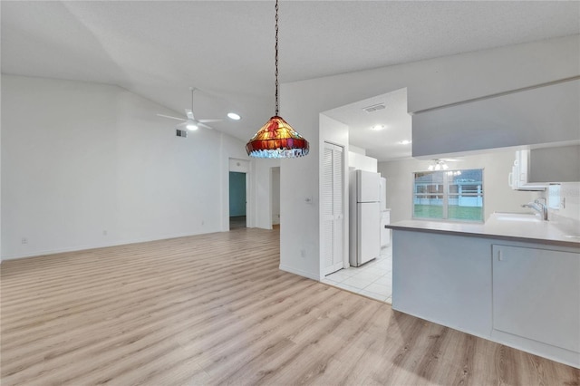 746 Masterpiece Dr, Sun City Center, FL 33573 - kitchen with freestanding refrigerator, ceiling fan, light wood finished floors, lofted ceiling, and decorative light fixtures