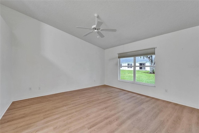 746 Masterpiece Dr, Sun City Center, FL 33573 - unfurnished room with lofted ceiling, light wood finished floors, a ceiling fan, and a textured ceiling