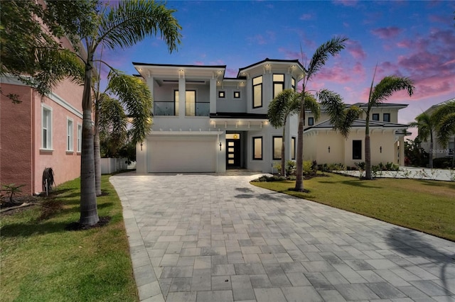 6520 Simone Shores Cir, Apollo Beach, FL 33572 - contemporary house featuring a garage, decorative driveway, a yard, a balcony, and stucco siding