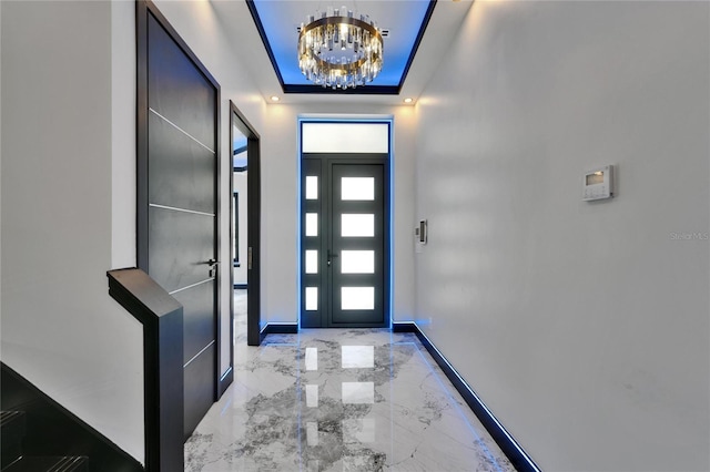 6520 Simone Shores Cir, Apollo Beach, FL 33572 - entrance foyer with a chandelier, marble tiled floors, a raised ceiling, and baseboards