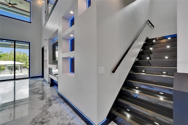 6520 Simone Shores Cir, Apollo Beach, FL 33572 - stairway with a towering ceiling, marble tiled floors, and baseboards