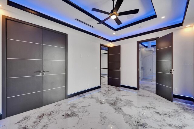 6520 Simone Shores Cir, Apollo Beach, FL 33572 - unfurnished bedroom featuring a raised ceiling, marble tiled flooring, baseboards, recessed lighting, and connected bathroom