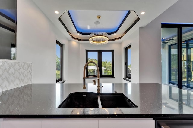6520 Simone Shores Cir, Apollo Beach, FL 33572 - kitchen featuring a sink, dark stone countertops, white cabinets, and a tray ceiling