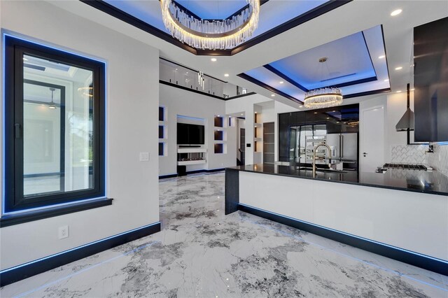 6520 Simone Shores Cir, Apollo Beach, FL 33572 - kitchen featuring dark countertops, a tray ceiling, tasteful backsplash, baseboards, and a sink