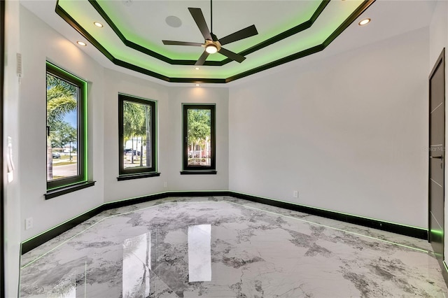 6526 Simone Shores Cir, Apollo Beach, FL 33572 - unfurnished room featuring ceiling fan, a raised ceiling, marble tiled floors, baseboards, and recessed lighting