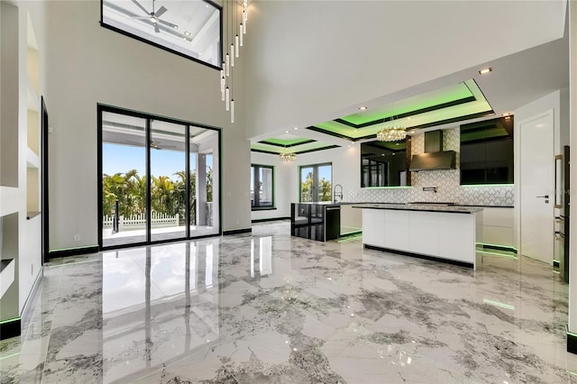 6526 Simone Shores Cir, Apollo Beach, FL 33572 - unfurnished living room featuring light marble finish floors, a chandelier, and plenty of natural light