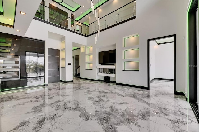 6526 Simone Shores Cir, Apollo Beach, FL 33572 - unfurnished living room with marble tiled floors, a high ceiling, and baseboards