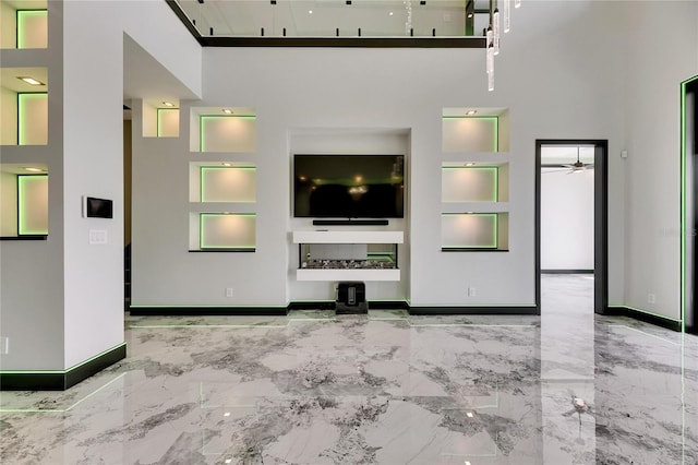 6526 Simone Shores Cir, Apollo Beach, FL 33572 - unfurnished living room with built in shelves, baseboards, a high ceiling, and a ceiling fan