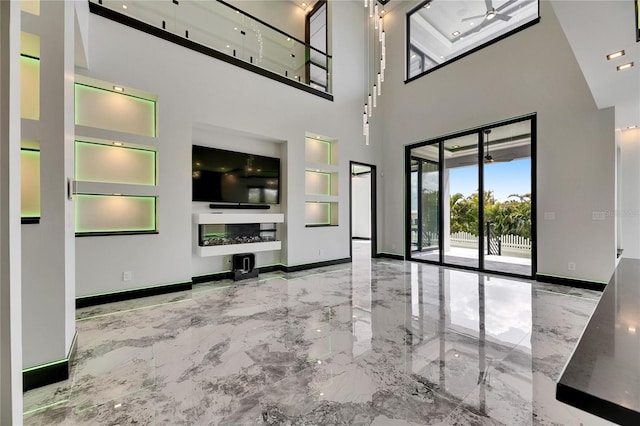 6526 Simone Shores Cir, Apollo Beach, FL 33572 - unfurnished living room featuring marble tiled floors, built in shelves, baseboards, and a high ceiling