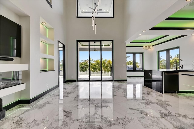 6526 Simone Shores Cir, Apollo Beach, FL 33572 - unfurnished living room featuring a chandelier, a sink, marble tiled flooring, built in shelves, and baseboards
