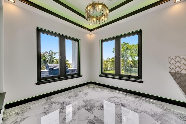 6526 Simone Shores Cir, Apollo Beach, FL 33572 - empty room featuring plenty of natural light, a chandelier, marble finish floors, ornamental molding, and baseboards