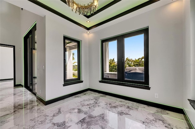 6526 Simone Shores Cir, Apollo Beach, FL 33572 - empty room featuring baseboards, light marble finish flooring, a chandelier, and crown molding