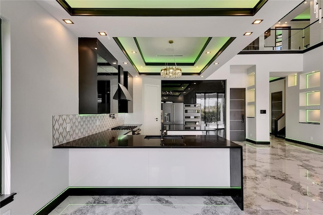 6526 Simone Shores Cir, Apollo Beach, FL 33572 - kitchen with marble tiled floors, wall chimney exhaust hood, a chandelier, a sink, and decorative backsplash