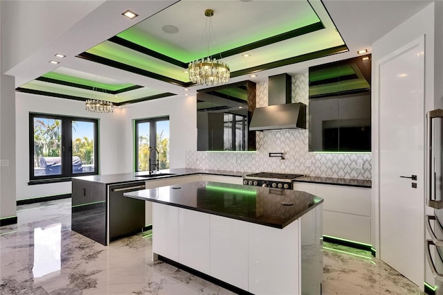 6526 Simone Shores Cir, Apollo Beach, FL 33572 - kitchen featuring appliances with stainless steel finishes, a chandelier, wall chimney exhaust hood, a raised ceiling, and recessed lighting