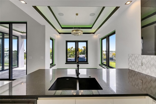 6526 Simone Shores Cir, Apollo Beach, FL 33572 - kitchen with a sink, a chandelier, dark stone counters, backsplash, and dishwasher
