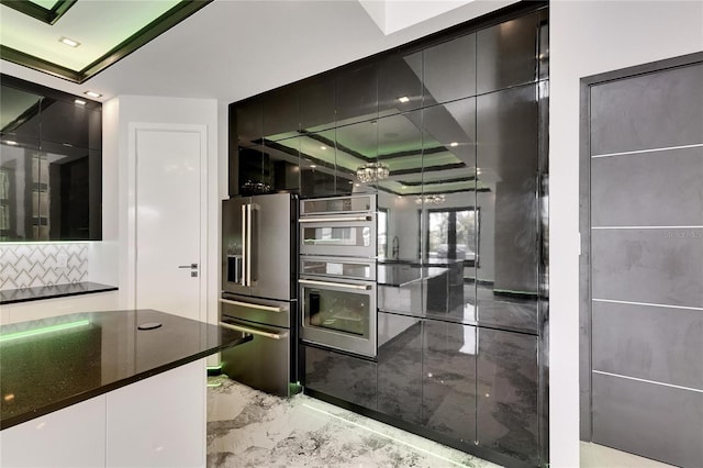 6526 Simone Shores Cir, Apollo Beach, FL 33572 - kitchen featuring appliances with stainless steel finishes, light marble finish floors, dark countertops, modern cabinets, and tasteful backsplash
