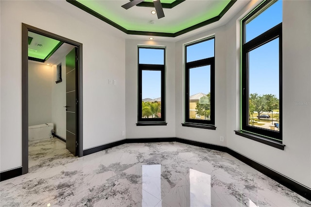 6526 Simone Shores Cir, Apollo Beach, FL 33572 - empty room with marble finish floors, baseboards, a raised ceiling, and a ceiling fan