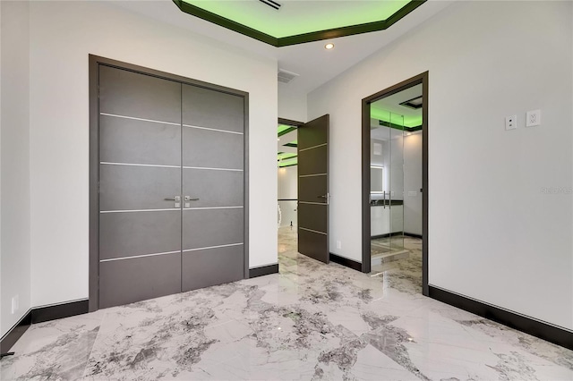 6526 Simone Shores Cir, Apollo Beach, FL 33572 - unfurnished bedroom with marble tiled floors, baseboards, recessed lighting, a closet, and connected bathroom