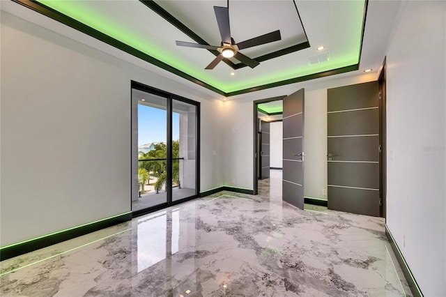 6526 Simone Shores Cir, Apollo Beach, FL 33572 - unfurnished bedroom featuring a tray ceiling, access to exterior, marble tiled flooring, baseboards, and recessed lighting