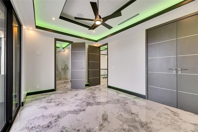 6526 Simone Shores Cir, Apollo Beach, FL 33572 - unfurnished bedroom featuring a raised ceiling, marble tiled flooring, baseboards, ensuite bath, and recessed lighting