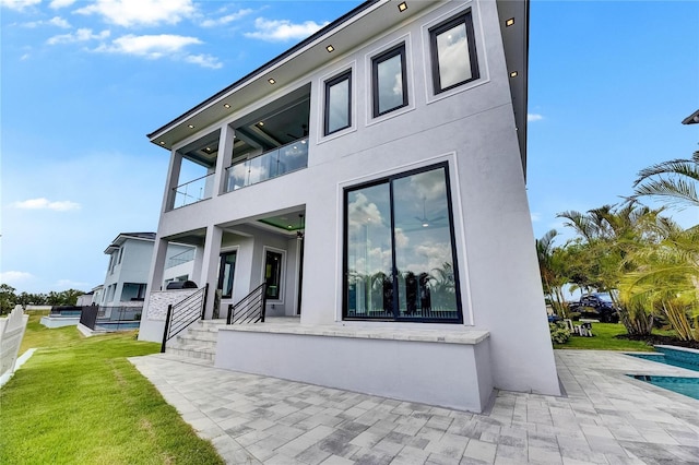 6526 Simone Shores Cir, Apollo Beach, FL 33572 - rear view of house with stucco siding, a patio, an outdoor pool, and a yard
