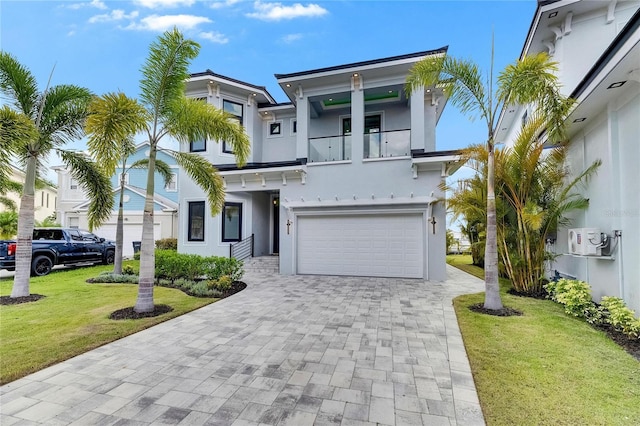 6526 Simone Shores Cir, Apollo Beach, FL 33572 - view of front of house featuring stucco siding, a garage, a balcony, a front lawn, and decorative driveway