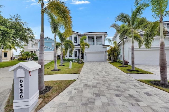 6526 Simone Shores Cir, Apollo Beach, FL 33572 - raised beach house featuring decorative driveway, a balcony, a front yard, a garage, and stucco siding