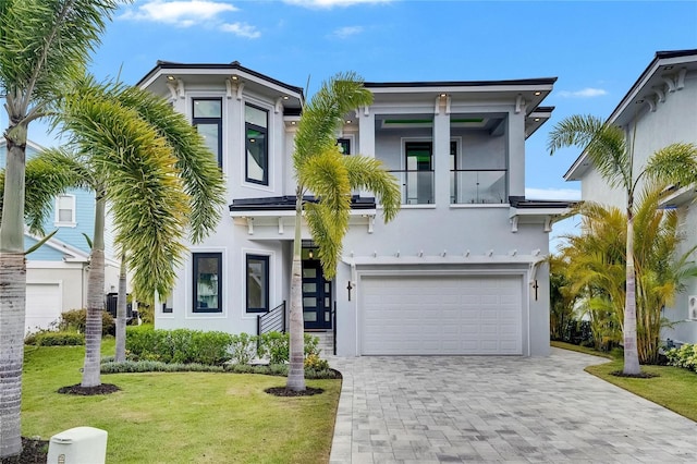6526 Simone Shores Cir, Apollo Beach, FL 33572 - italianate-style house with a garage, stucco siding, a front lawn, decorative driveway, and a balcony