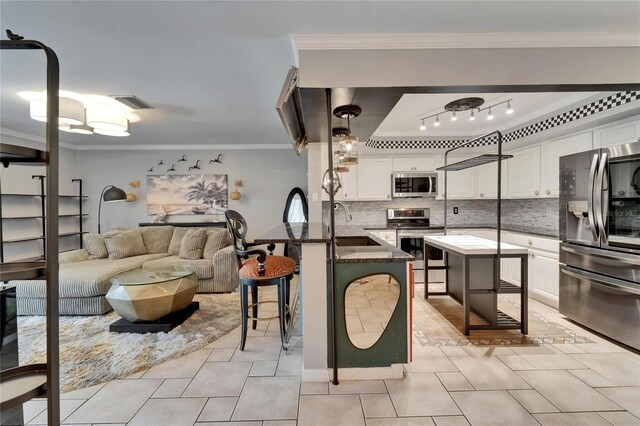 644 Yardarm Dr Unit 22, Apollo Beach, FL 33572 - kitchen featuring appliances with stainless steel finishes, a breakfast bar, white cabinets, crown molding, and a peninsula