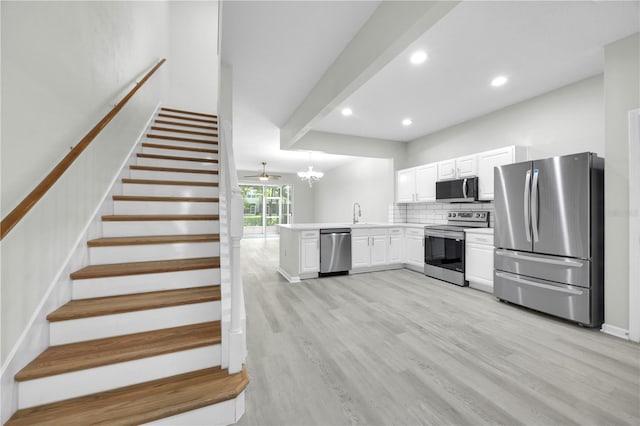 4910 Chatham Gate Drive Dr, Riverview, FL 33578 - kitchen with stainless steel appliances, a peninsula, white cabinetry, tasteful backsplash, and light wood-style flooring