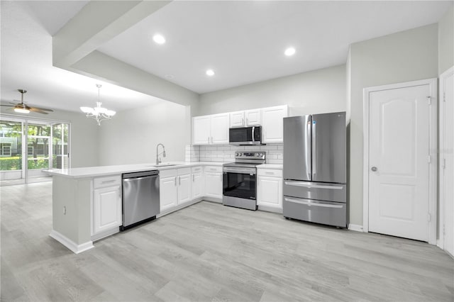 4910 Chatham Gate Drive Dr, Riverview, FL 33578 - kitchen with stainless steel appliances, a sink, a peninsula, a ceiling fan, and white cabinets