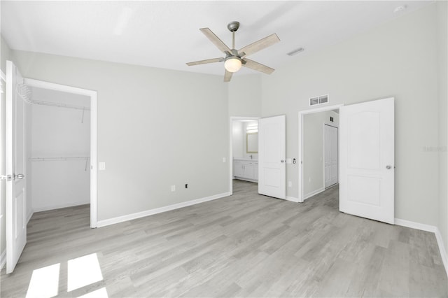 4910 Chatham Gate Drive Dr, Riverview, FL 33578 - unfurnished bedroom with a spacious closet, light wood finished floors, baseboards, a closet, and a towering ceiling